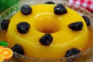 Manjar de laranja sem leite coberto com calda e ameixas